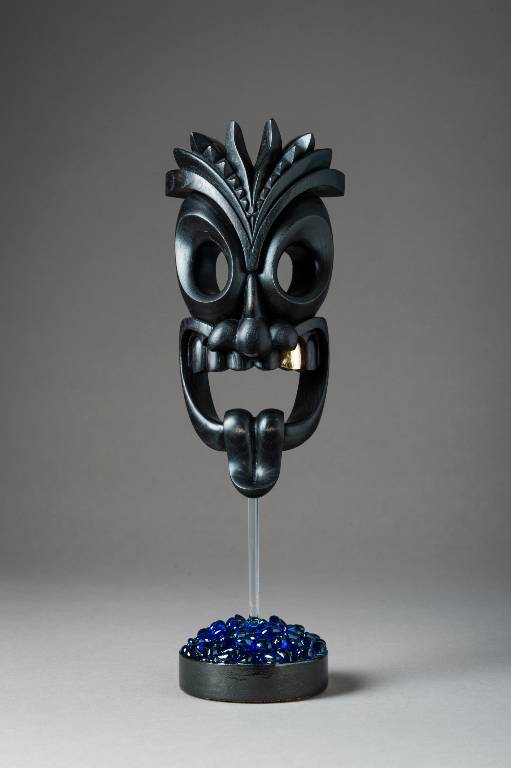 A tiki inspired carved wood sculpture in ebonised ash